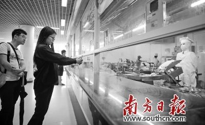 “美女”机器人在华农饭堂做刀削面，吸引了许多学生前来品尝面食。